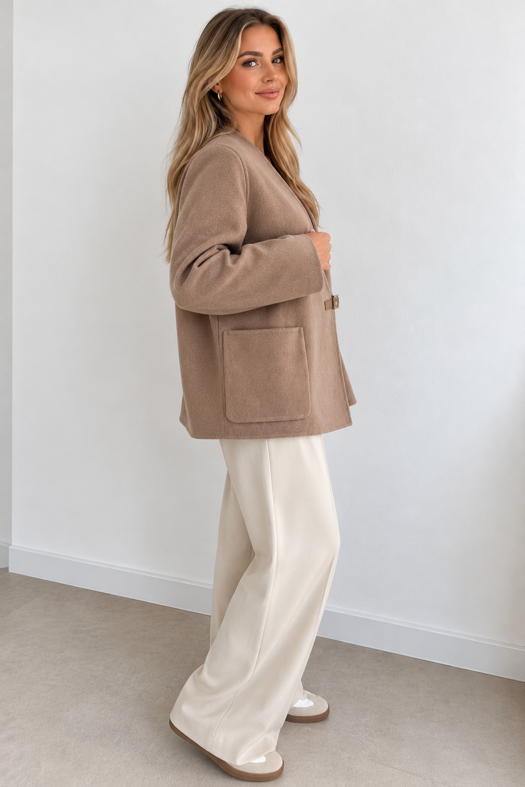 Side view of a model wearing a taupe wool and cashmere jacket, showing its relaxed fit and large patch pocket – Darivé Select